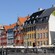 A bridge over a canal lined with cafes and historical gabled buildings